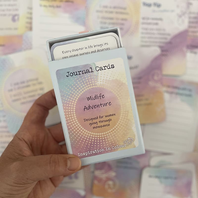 A hand holding a box of 'Journal Cards: Wildlife Adventure' cards, with other cards blurred in the background.