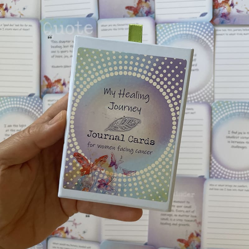 My Healing Journey Journal Cards – journal deck for women facing cancer, boxed set with green ribbon pull and butterfly design, held in hand.